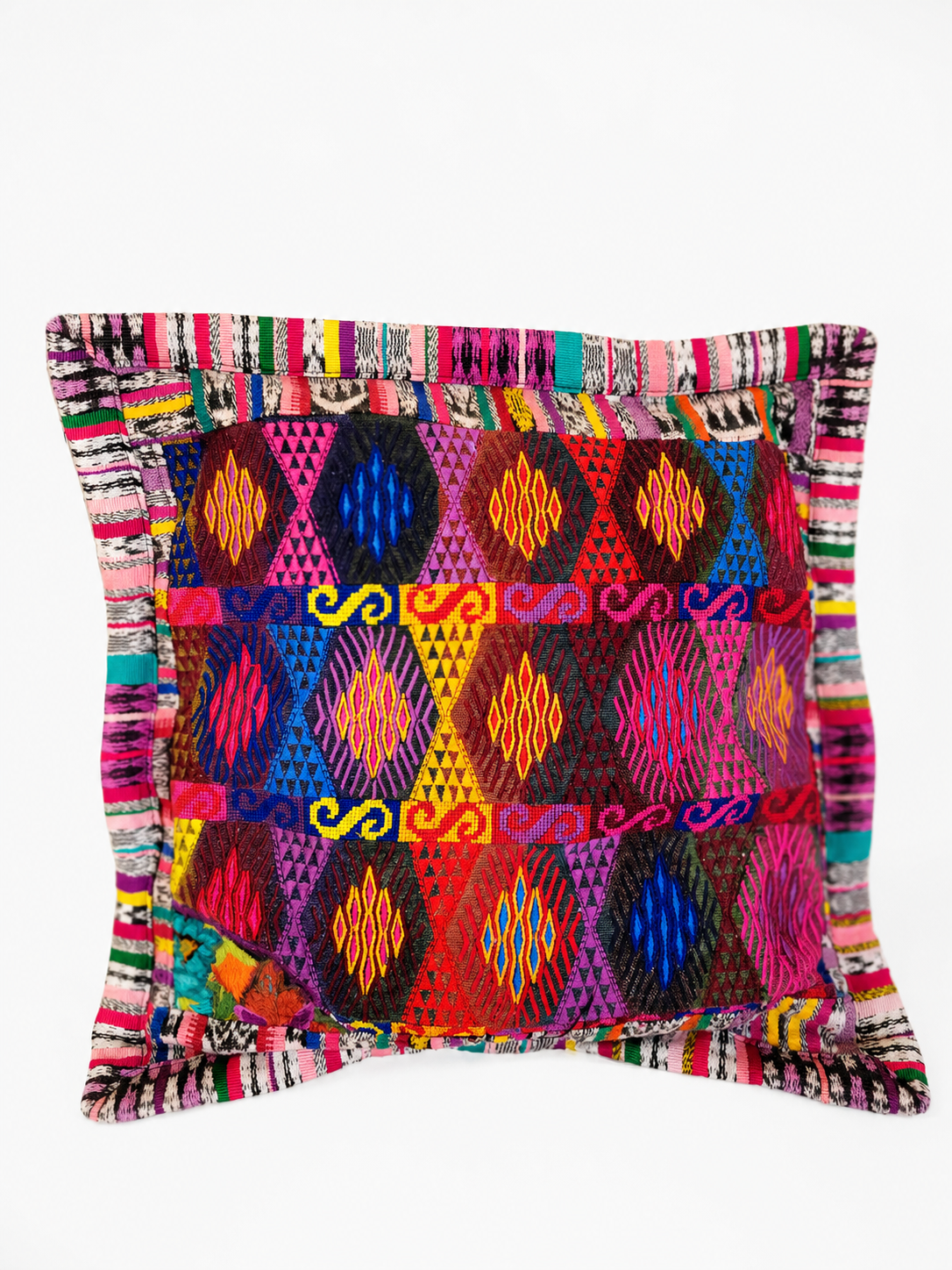 TQC pillow cover showing layered diamond and rhombus motifs in vivid reds, pinks, and blues